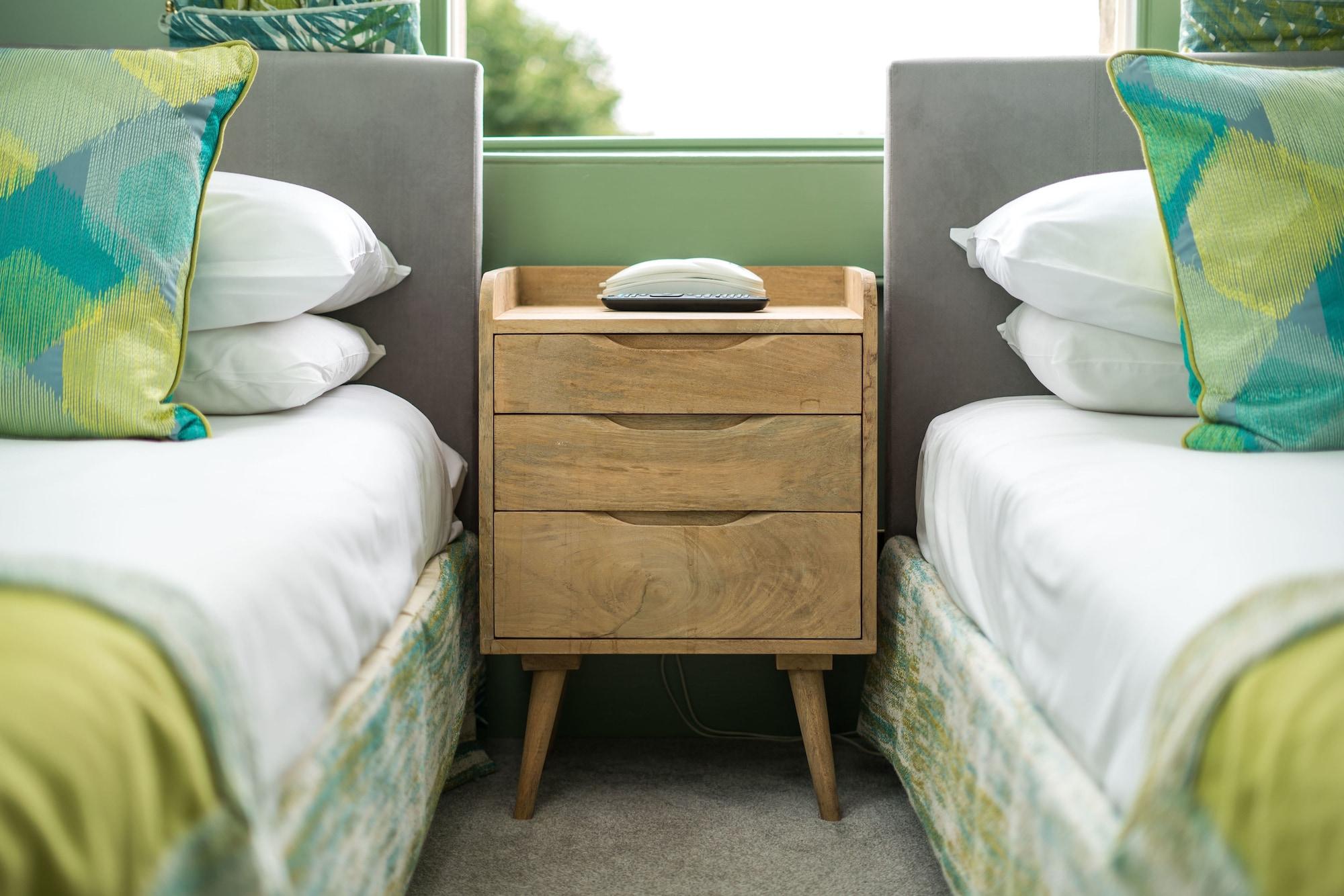 The Ayrlington Guesthouse Bath Bagian luar foto A bedside table