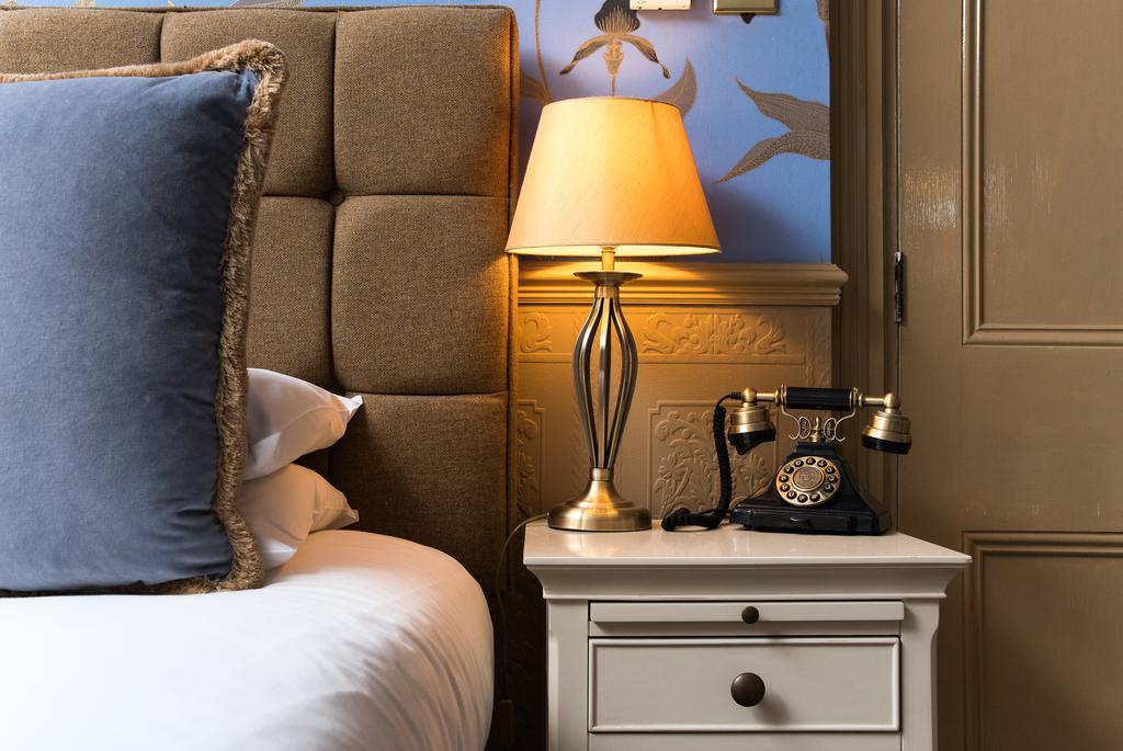 The Ayrlington Guesthouse Bath Bagian luar foto A bedside table